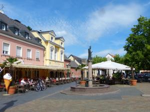 a town square with a fountain and people sitting at tables at Wohnen im alten Amtsgericht im Herzen von Xanten in Xanten
