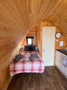 a bedroom with a bed in a log cabin at Arisaig Pods in Arisaig
