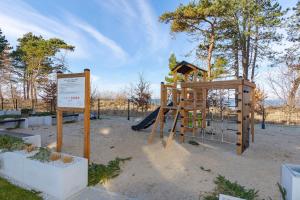 a playground with a slide and a sign at VacationClub - Let’s Sea Baltic Park B44 in Gąski