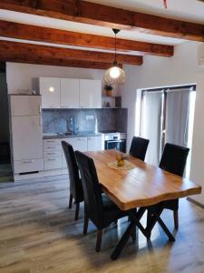 cocina y comedor con mesa de madera y sillas en Homestead Zavadlal - Domačija Zavadlal, en Komen