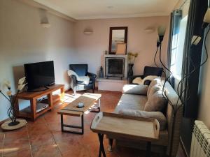 een woonkamer met een bank en een tv bij Casa-Estaro in Anceriz