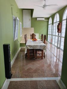 een eetkamer met een tafel en stoelen en groene muren bij Finca Campo Viejo in Isla Cristina