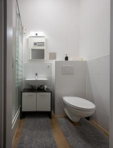 Baño blanco con aseo y lavamanos en Radiant Premium Apartments-Muhrengasse, en Viena