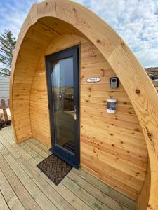 a circular wooden building with a door on a deck at Arisaig Pods in Arisaig