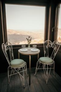 a table and two chairs in a room with a window at B&B La Castellina in Abbadia San Salvatore
