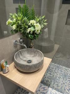 a bathroom with a sink with a vase of flowers at Vitamin Sea Protaras in Protaras +18 photos