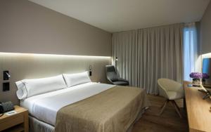 Vilassar de DaltにあるHotel Sorli Emocionsの大きなベッドとデスクが備わるホテルルームです。