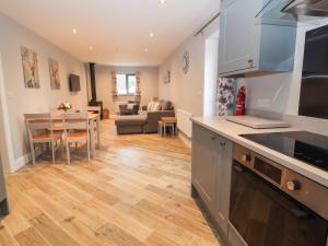 eine Küche und ein Wohnzimmer mit einem Tisch und einem Sofa in der Unterkunft Timadon Cottage in Chester