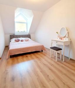 a bedroom with a bed and a desk and a window at Apartmán Frida in Nová Baňa
