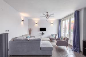 a living room with a couch and chairs and a tv at L'Escale Marine in Dunkerque