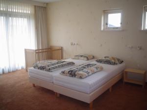 2 łóżka pojedyncze w pokoju z oknem w obiekcie Villa de Molenhof w mieście Reutum