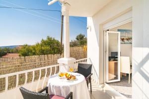 una mesa con un bol de fruta en el balcón en Apartments Blažević, en Mlini