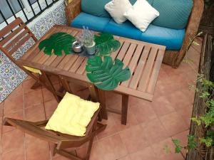 una mesa de madera y sillas en un patio con sofá en Calle Bastión, 2 Apartamento 3, en Torremolinos