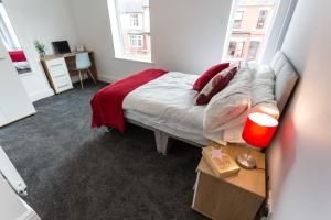 ein Schlafzimmer mit einem Bett mit einer roten Decke in der Unterkunft Beamont House in Warrington