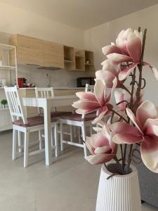 a white vase with pink flowers in a kitchen at Romeo&Giulietta in Monopoli