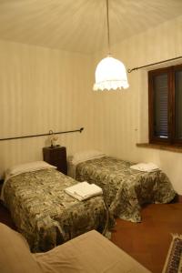 a hotel room with two beds and a light at Fonte del Salcio in Cinigiano