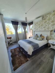 1 dormitorio con cama grande y ventana grande en Boutique villa on the rocks with Sea, jetty, infinity pool, garden, daily housekeeping, Cook, en Trou d'Eau Douce