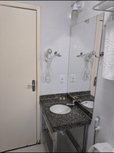 y baño con lavabo y espejo. en Lacqua diRoma com ABD-TURISMO- Hotéis e Parques uma DIVERSÃO GARANTIDA, en Caldas Novas