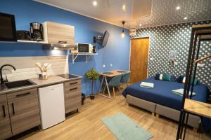 a small room with a bed and a kitchen at Capstay Color Valenciennes & Netflix in Saint-Léger