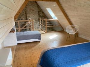 a attic room with a bed and a staircase at Le Clos de Kermadec in Kervignac