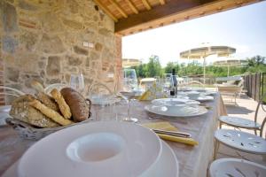 una mesa con platos blancos y copas de vino. en Villa Gourmet, en Orentano