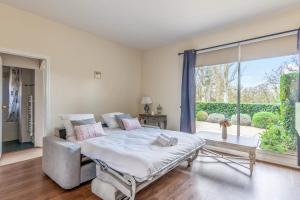 ein Schlafzimmer mit einem Bett und einem großen Fenster in der Unterkunft Nice flat in a beautiful estate 15 min by walk from Deauville - Welkeys in Tourgéville