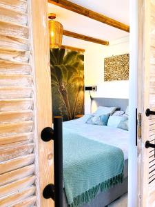 een slaapkamer met een bed met een blauwe sprei bij Zandvoort Paradise Boutique Chambre in Zandvoort