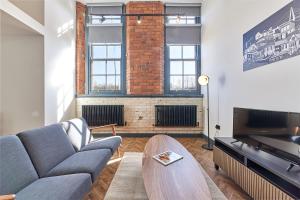 a living room with a couch and a fireplace at No 2 at Simpson Street Apartments Sunderland in Sunderland