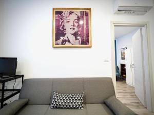 sala de estar con sofá y una foto en la pared en DIMORA SOTTORIPA 24 DI FRONTE ALL’ACQUARIO - GENOVABNB IT, en Génova