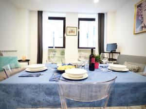 una mesa de comedor con platos y copas de vino en DIMORA SOTTORIPA 24 DI FRONTE ALL’ACQUARIO - GENOVABNB IT, en Génova