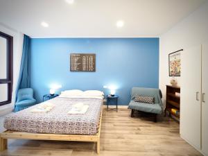 1 dormitorio con cama y pared azul en DIMORA SOTTORIPA 24 DI FRONTE ALL’ACQUARIO - GENOVABNB IT, en Génova