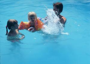 a woman and two children playing in the water at Frühstückspension Binder in Harbach