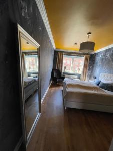 1 dormitorio con espejo grande y cama en Fördestyle, Stilvolle Wohnung in zentraler Lage en Kiel