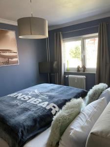 1 dormitorio con 1 cama con pared azul en Fördestyle, Stilvolle Wohnung in zentraler Lage, en Kiel