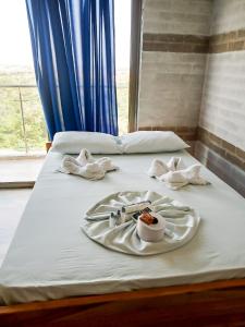 duas camas com toalhas e uma bandeja de comida sobre elas em Arenillas del Mar em Tolú