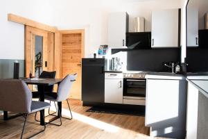 uma cozinha com mesa e cadeiras num quarto em Apartment Pult em Fendels