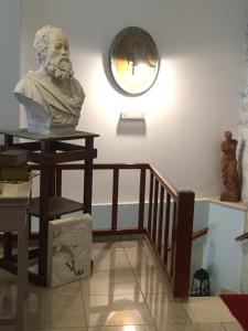 een buste van een man die op een tafel naast een trap zit bij Hotel George in Kalamata