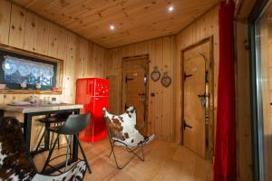 Zimmer mit einem Tisch und Stühlen sowie einem roten Kühlschrank. in der Unterkunft Domaine de l'Authentique Cabanes dans les arbres in Fournet-Blancheroche