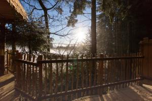 een houten hek met de zon op de achtergrond bij Domaine de l'Authentique Cabanes dans les arbres in Fournet-Blancheroche