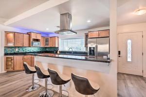 a kitchen with wooden cabinets and a bar with stools at Modern Villa min walk to Scottsdale W Hotel & City Center in Scottsdale