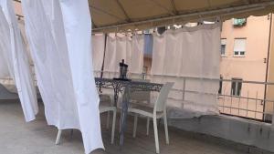 uma mesa e cadeiras numa varanda com cortinas brancas em Casa Vacanze Mare em Pescara