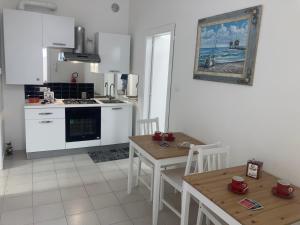 a kitchen with white appliances and a table and chairs at Casa Vacanze Mare in Pescara