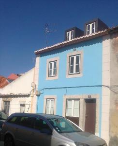 uma casa azul com um carro estacionado em frente em VillaHouse Carnide em Lisboa
