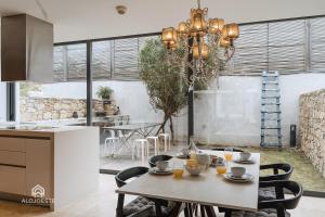 uma cozinha com uma mesa com cadeiras e um lustre em Quaint & Chic Seaside Villa em Santa Cruz