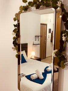 a mirror reflecting a bedroom with a bed and towels at Diamond Apartment in Athens