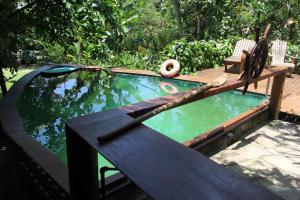a swimming pool with a table and a pool at Paraty Paradiso in Parati-Mirim
