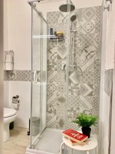 W łazience znajduje się prysznic ze szklanymi drzwiami. w obiekcie Urban Greener - MORADA w Cagliari +12 zdjęć