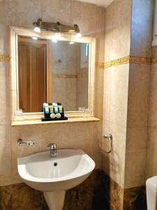 ein Bad mit einem Waschbecken und einem Spiegel in der Unterkunft Possidon in Agia Marina