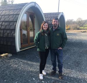 a man and a woman standing in front of a tiny house at Comeragh Pods in Kilmacthomas