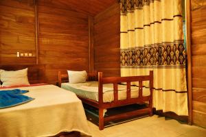 a room with two beds and a chair in it at Discovery resort in Ratnapura